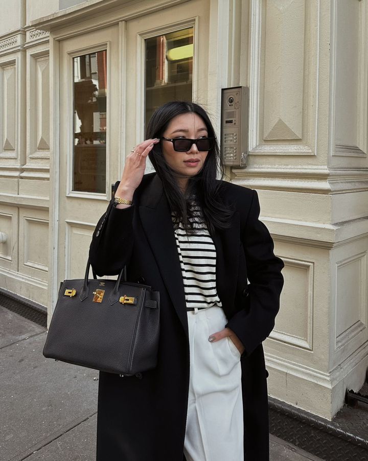 Photo of fashion content creator Alyssa Lenore wearing sunglasses on a city sidewalk. Photo credited to Alyssa Lenore
