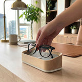 Woman placing glasses into a maple glasses valet.