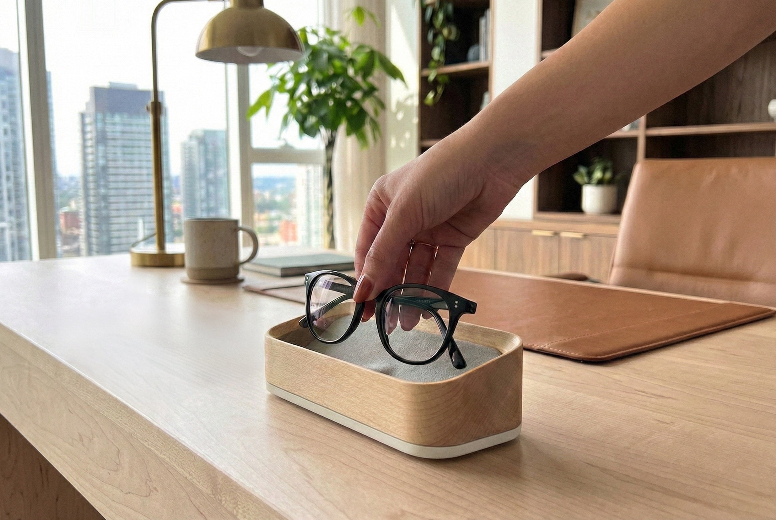 Woman placing glasses into a maple glasses valet.